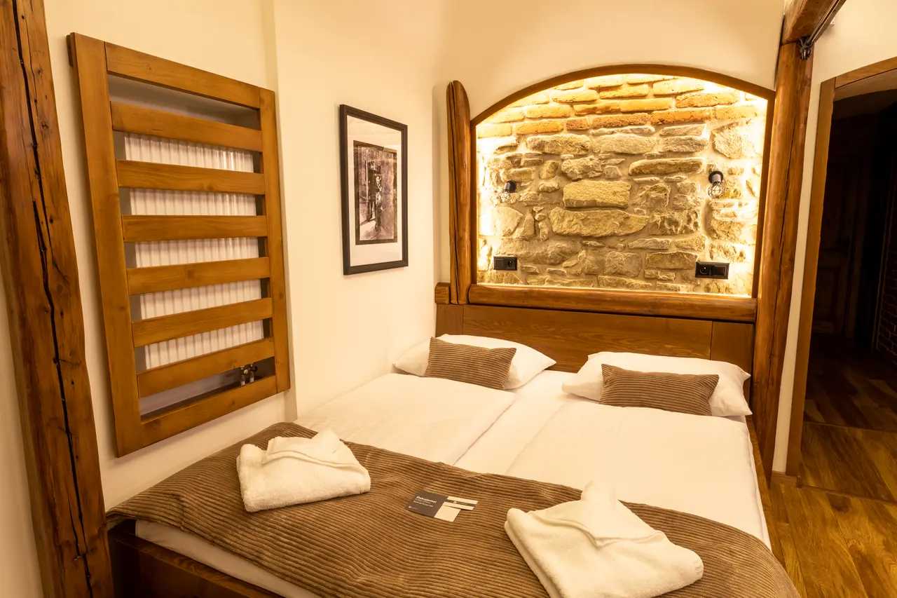 Spálňa apartmánu s podsvieteným kamenným múrom
