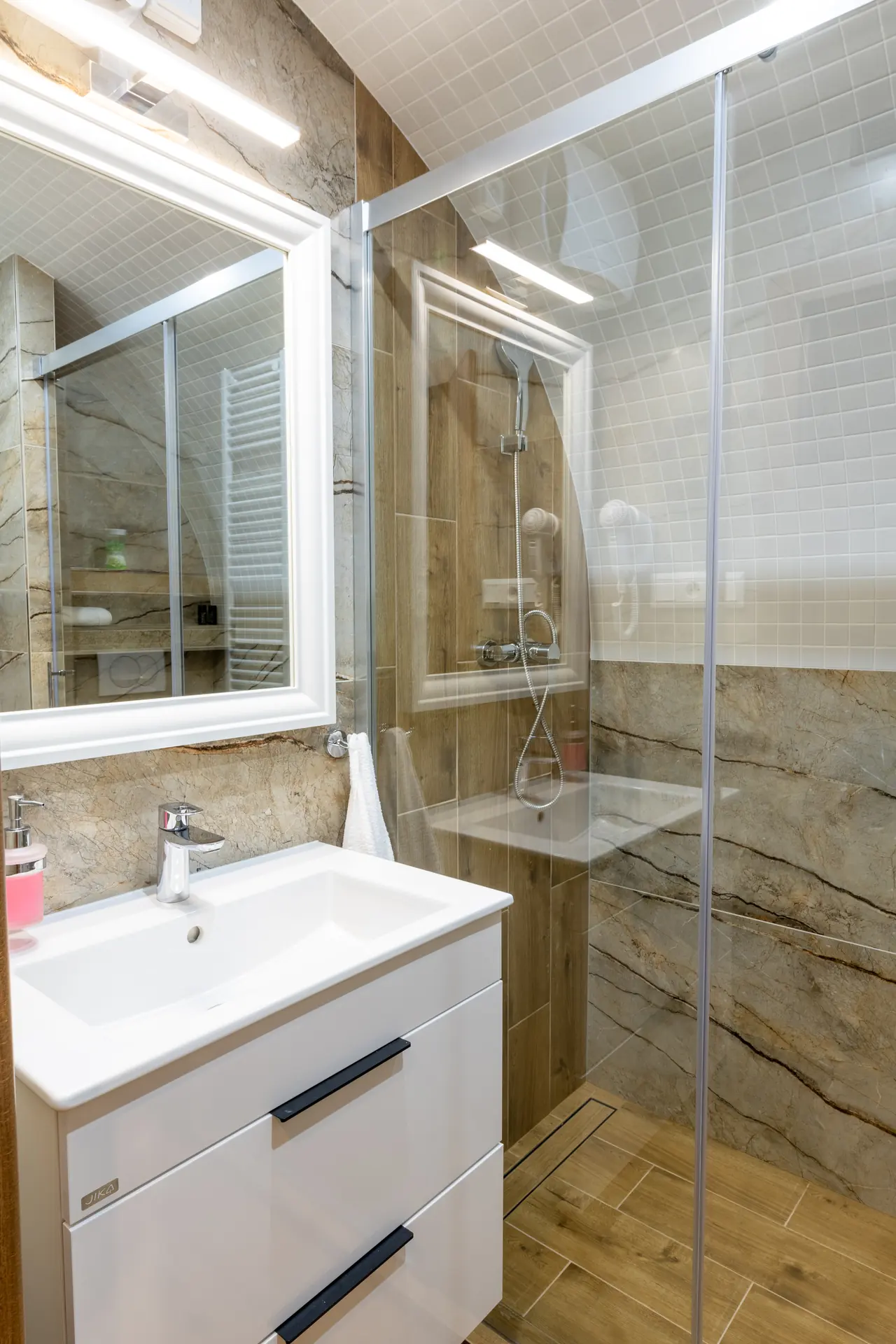 Kúpeľňa apartmánu s umývadlom a sprchovacím kútom