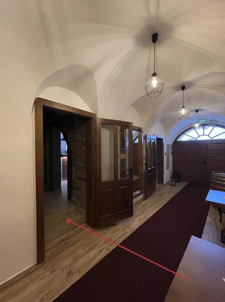 Vaulted hallway, the arrow points to the passage on the left towards the rooms